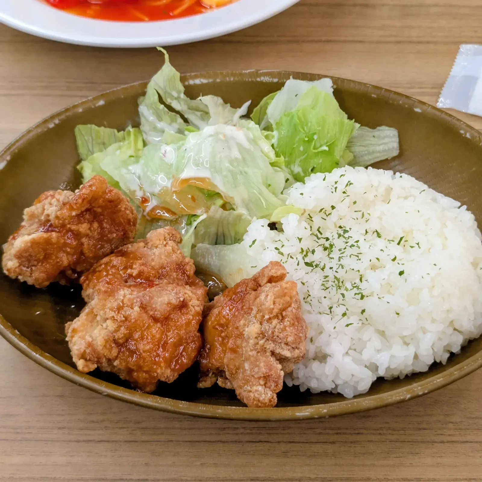 キッズランド内カフェテリアの唐揚げ定食。唐揚げ3個とサラダ、パセリをふったライス